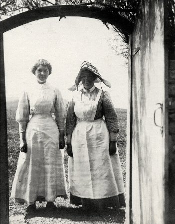 Mrs Treadwell, housekeeper to the Moorhouses, with another servant, 
at the side gate, 1913